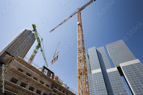 Crane lifting a wall on a construction site