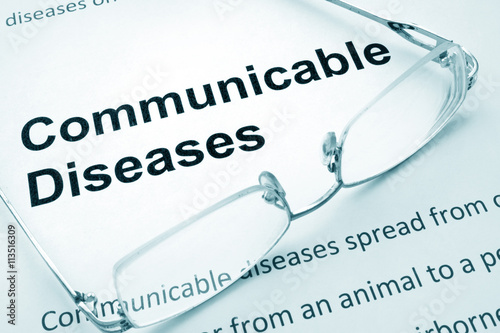 Paper with words  communicable diseases  and glasses. photo