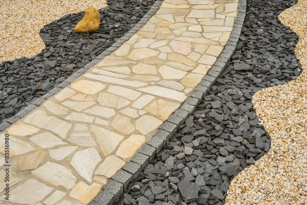 Gartenweg aus Natursteinplatten im Steingarten diagonal Diagonal