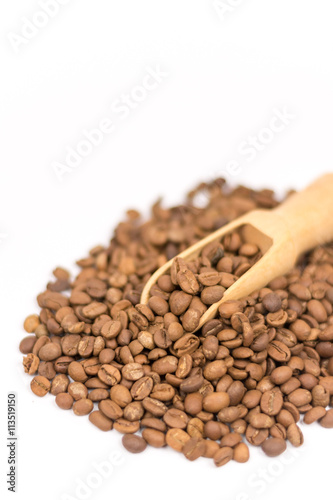 Raw coffee with wooden spoon