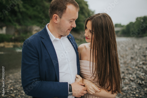 Young cute couple honeymoon posing and holding their hands on dating in a beautiful place italy near ocean and mountains, hug, smile and talk to each other 