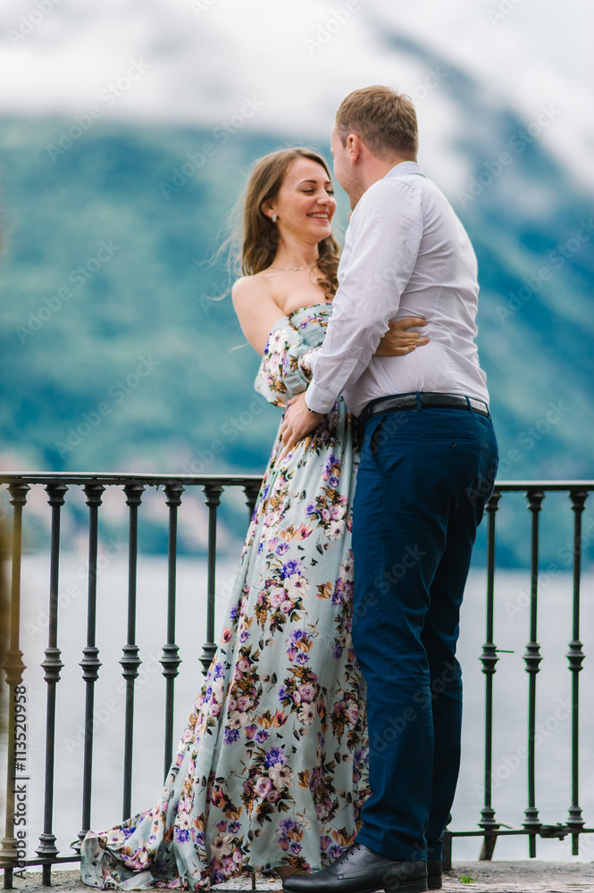 Young cute couple honeymoon walks holding their hands on dating in a beautiful place italy near ocean and mountains, hug, smile and talk to each other Young cute couple honeymoon walks holding their hands on dating in a beautiful place italy near ocean and mountains, hug, smile and talk to each other