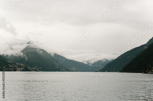 magnificent view of mountains clouds and small village near ocean water vintage look