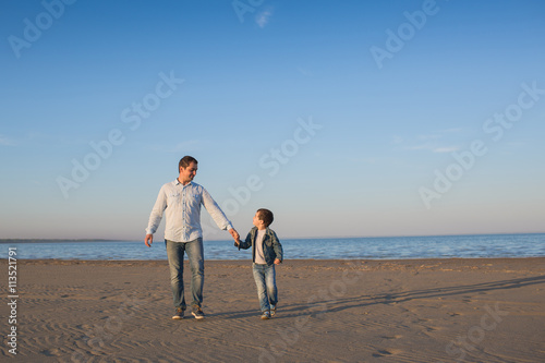 Father walks with his little son on a beach