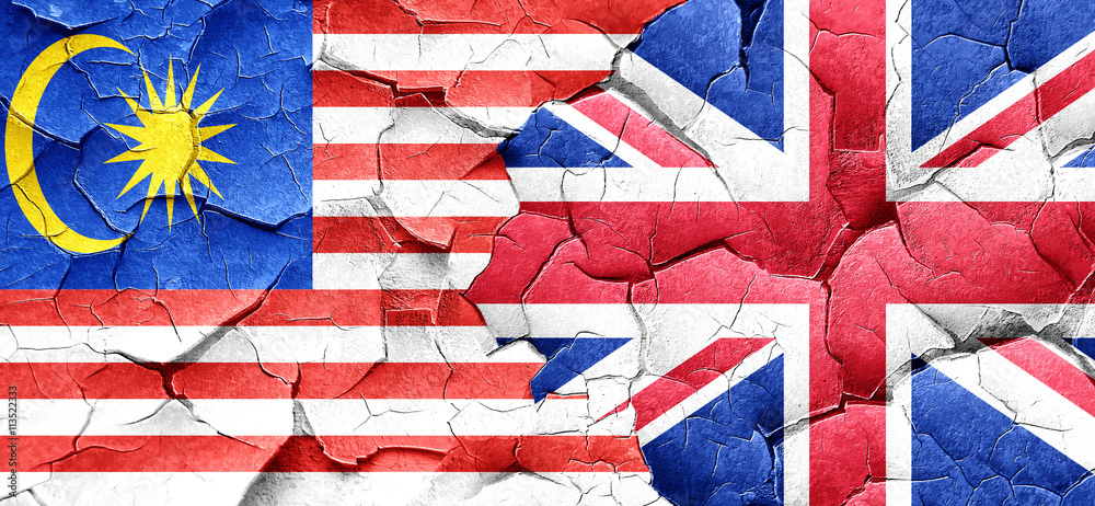 Fototapeta premium Malaysia flag with Great Britain flag on a grunge cracked wall