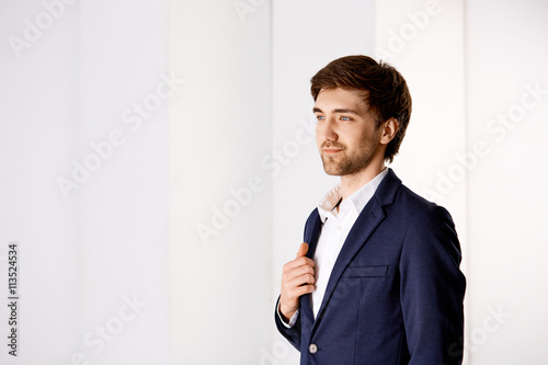 Young businessman standing near the office desk