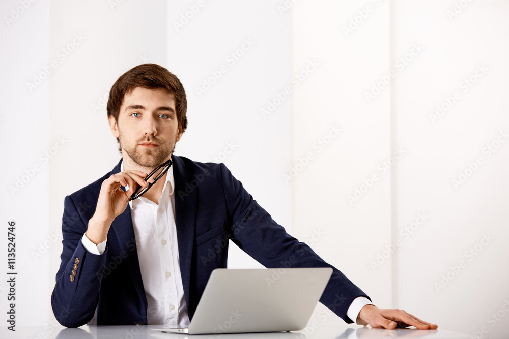 Young businessman sitting at the office desk Young businessman sitting at the office desk
