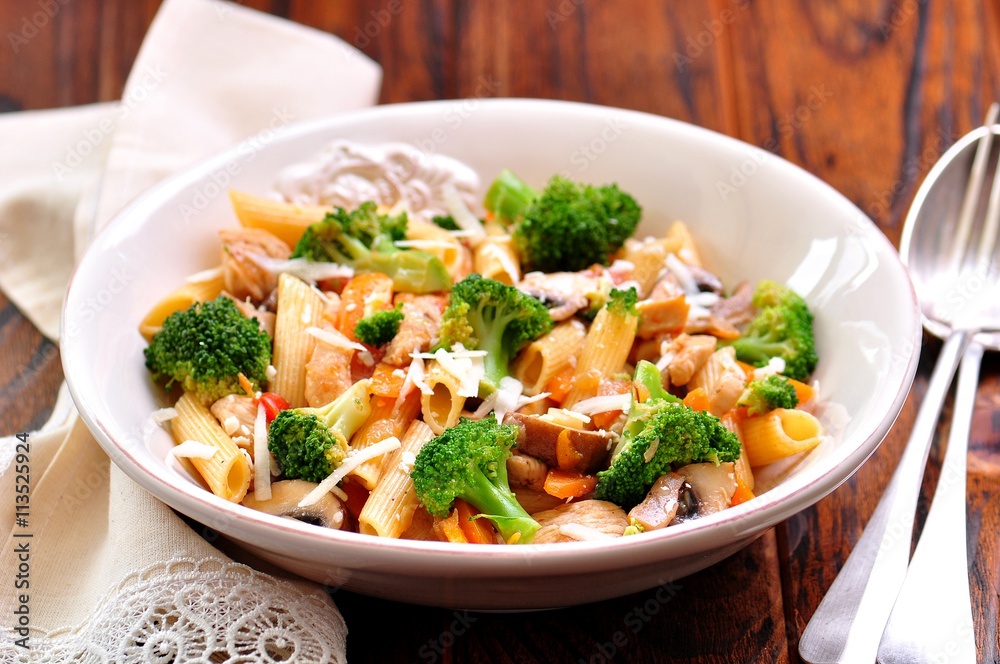 Fotografie Pasta with chicken, broccoli, carrots, tomatoes and parmesan