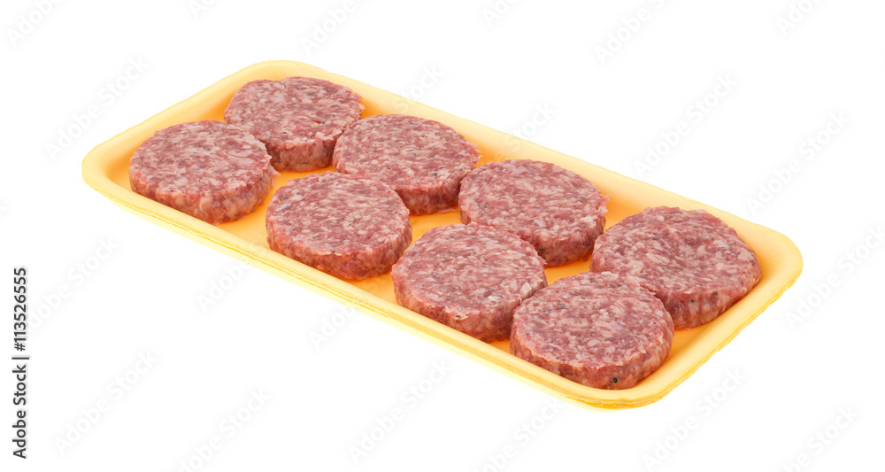 Sausage patties in a foam tray on a white background side view.