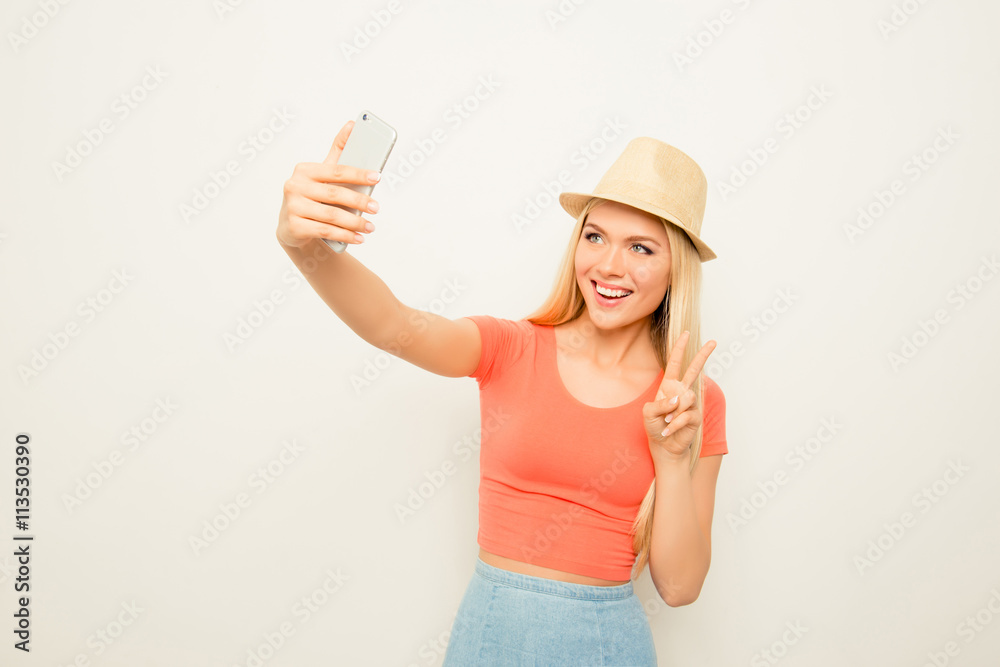 Cheerful happy woman making photo on smartphone and gesturing Cheerful happy woman making photo on smartphone and gesturing