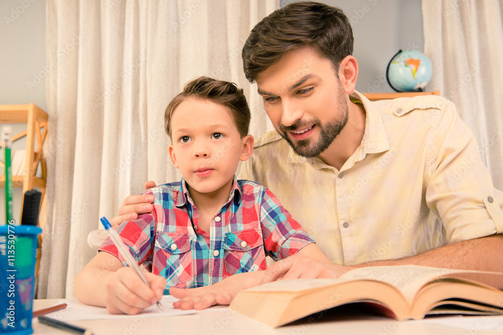Young father teaching little son how to write Young father teaching little son how to write
