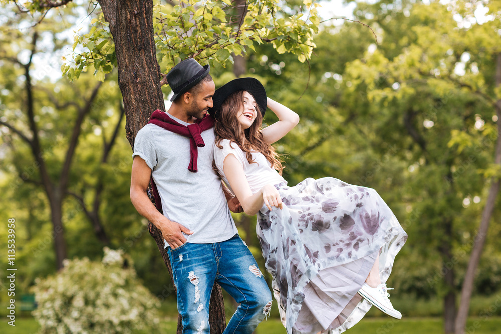 Couple standing and laughing outdoors Couple standing and laughing outdoors