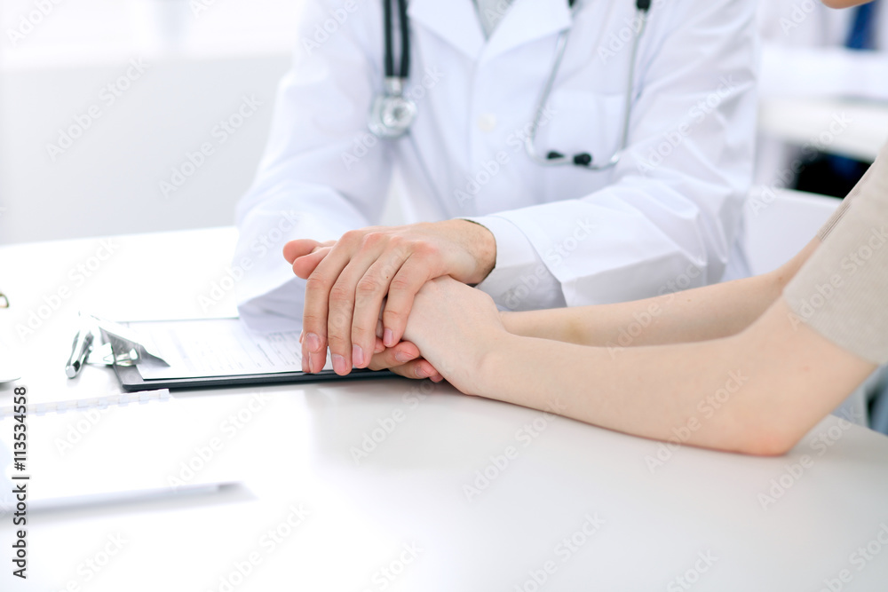 Hand of doctor reassuring her female patient
