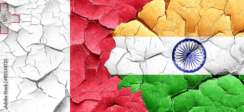 Malta flag with India flag on a grunge cracked wall