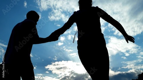 Boy and girl dancing salsa in backlight on the street.