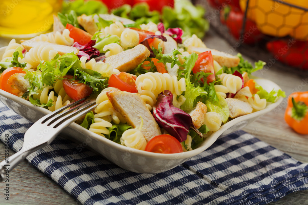 Noodle salad with green salad, tomatoes and roasted chicken.