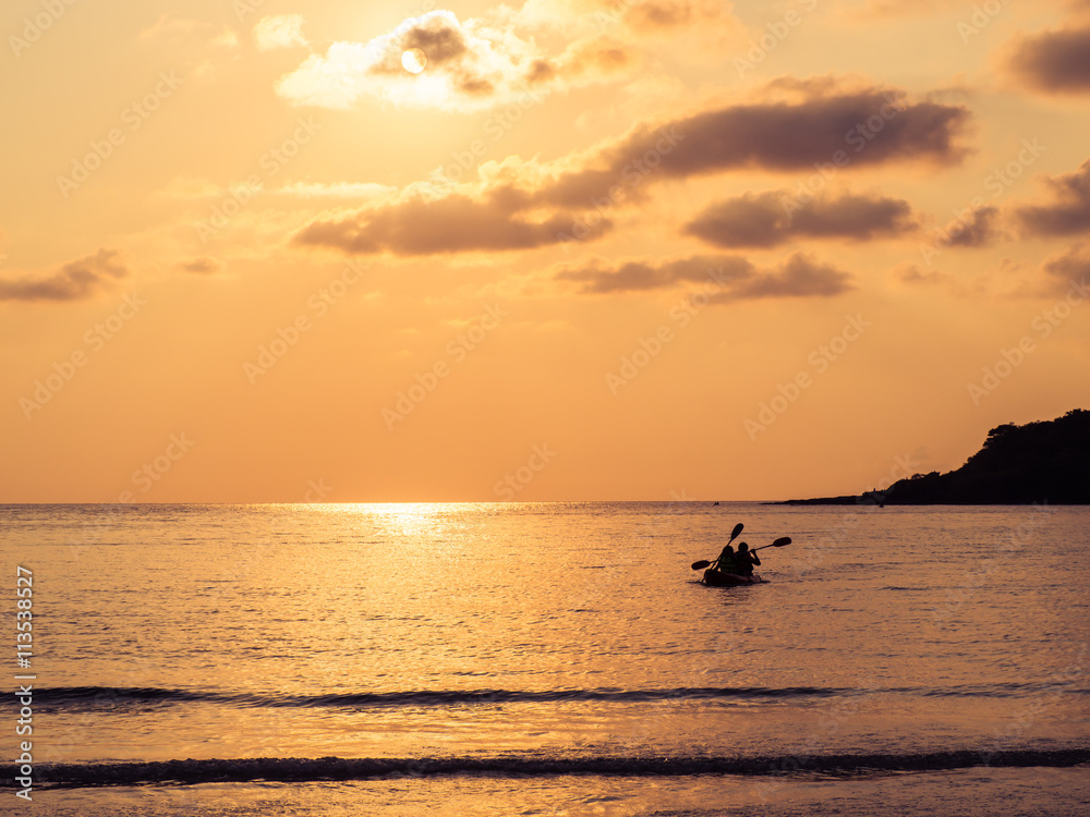 Silhouette of a lovely couple on a canoe boat during sunset