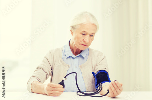 old woman with tonometer checking blood pressure