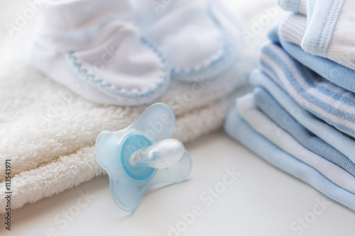 Vászonkép close up of soother and baby clothes for newborn
