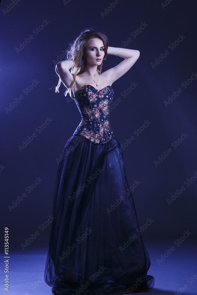 Portrait of a woman in a beautiful dress with a floral pattern in the Studio Portrait of a woman in a beautiful dress with a floral pattern in the Studio