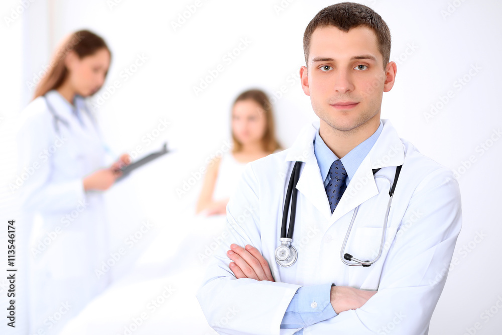 Friendly male doctor on the background with patient in the bed and his doctor Friendly male doctor on the background with patient in the bed and his doctor