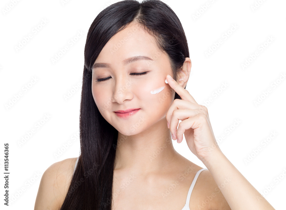 Asian female skincare of her face by applying cosmetic cream Asian female skincare of her face by applying cosmetic cream