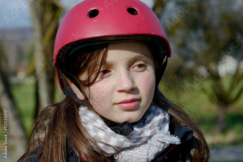 Teenage girl wearing a roller skate helmet.