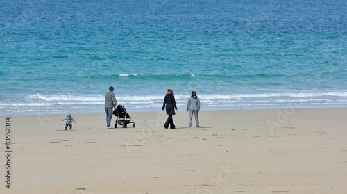 Une famille avec une poussette se promène sur la plage de Trestraou à Perros-Guirec en Bretagne photo