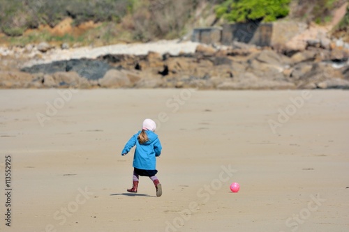 Une fillette joue au ballon sur la plage à Perros-Guirec en Bretagne