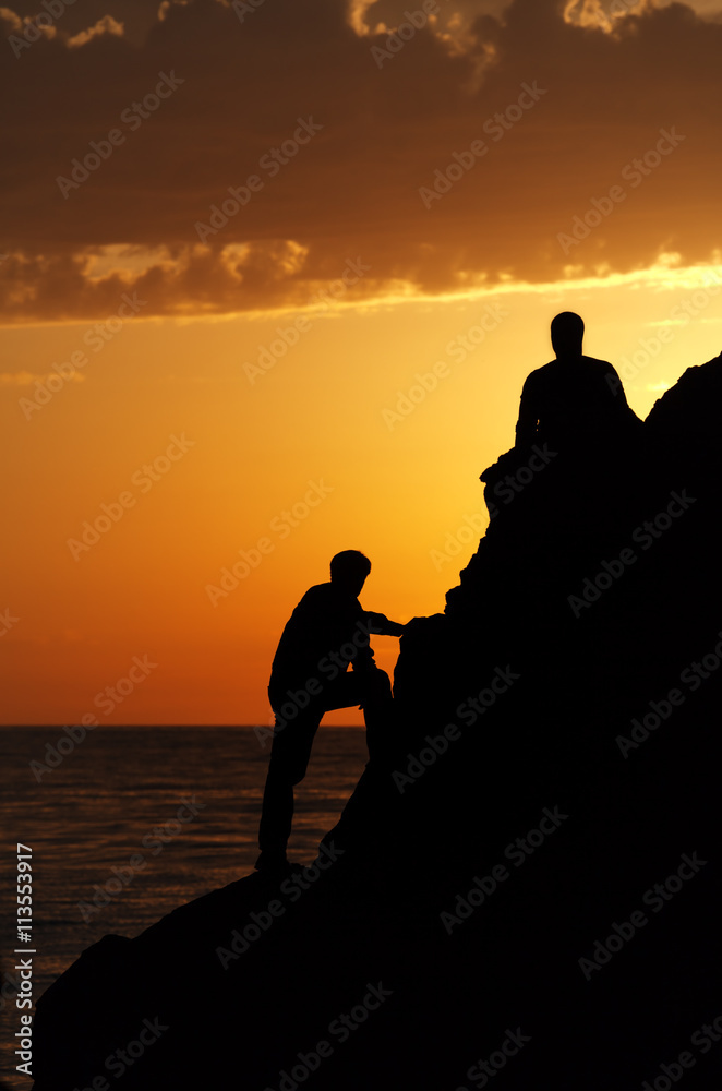 Two silhouette of people in beautiful sunset