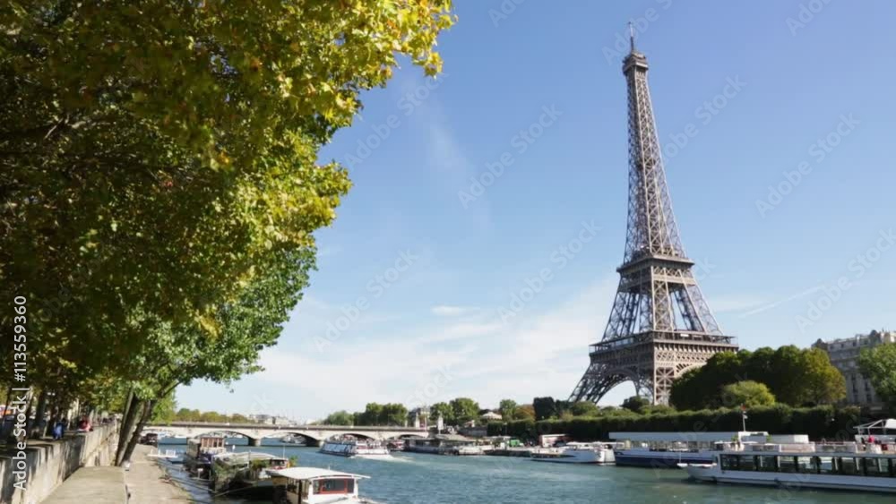 Eiffel tower and Seine river in a sunny day in Paris, boat passing
