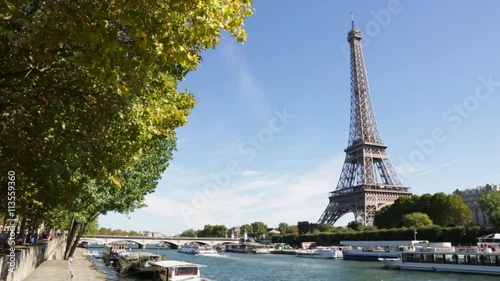 Eiffel tower and Seine river in a sunny day in Paris, boat passing
