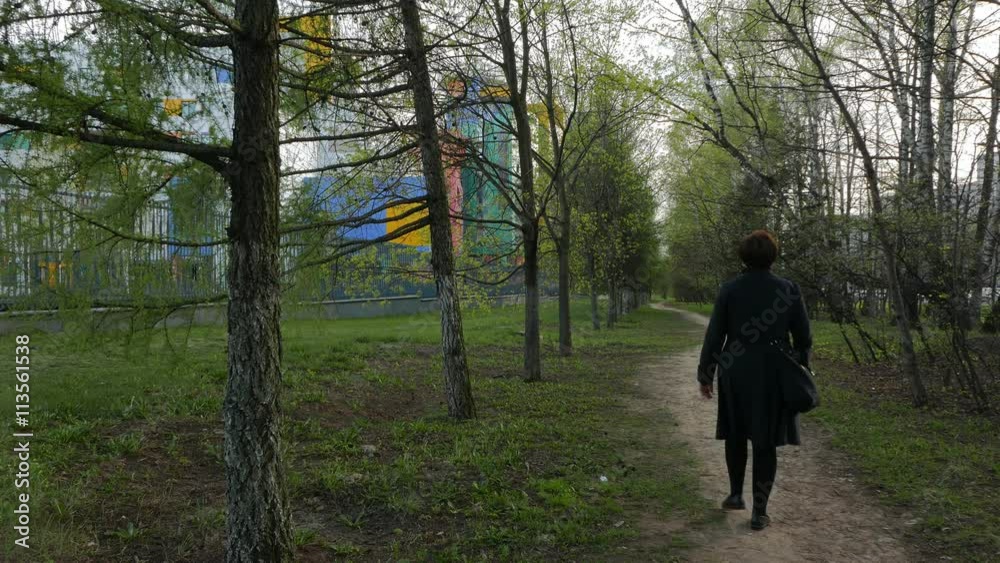 Lonely Woman Walking on a Path Surrounded Trees. Lonely Woman Walking on a Path Surrounded Trees.