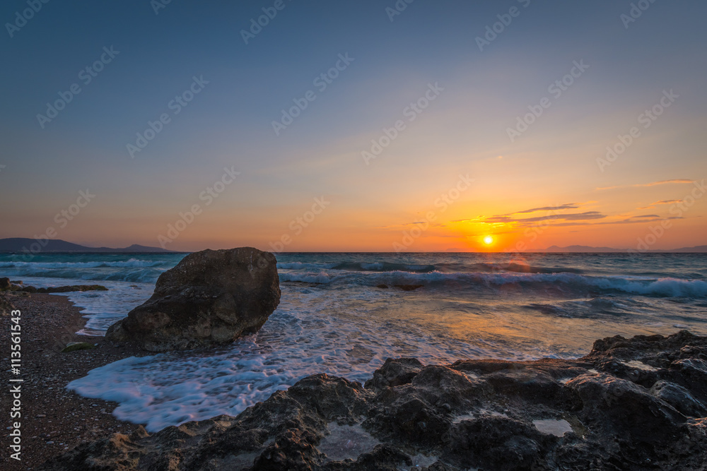 Sunset in Rhodes, Greece with stones in the sea