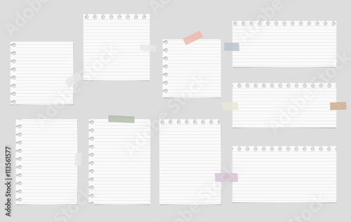 Pieces of cut out white notebook paper are stuck on gray striped background
