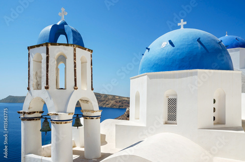 Classic view of white church with blue domes - Oia village, Santorini Island in Greece