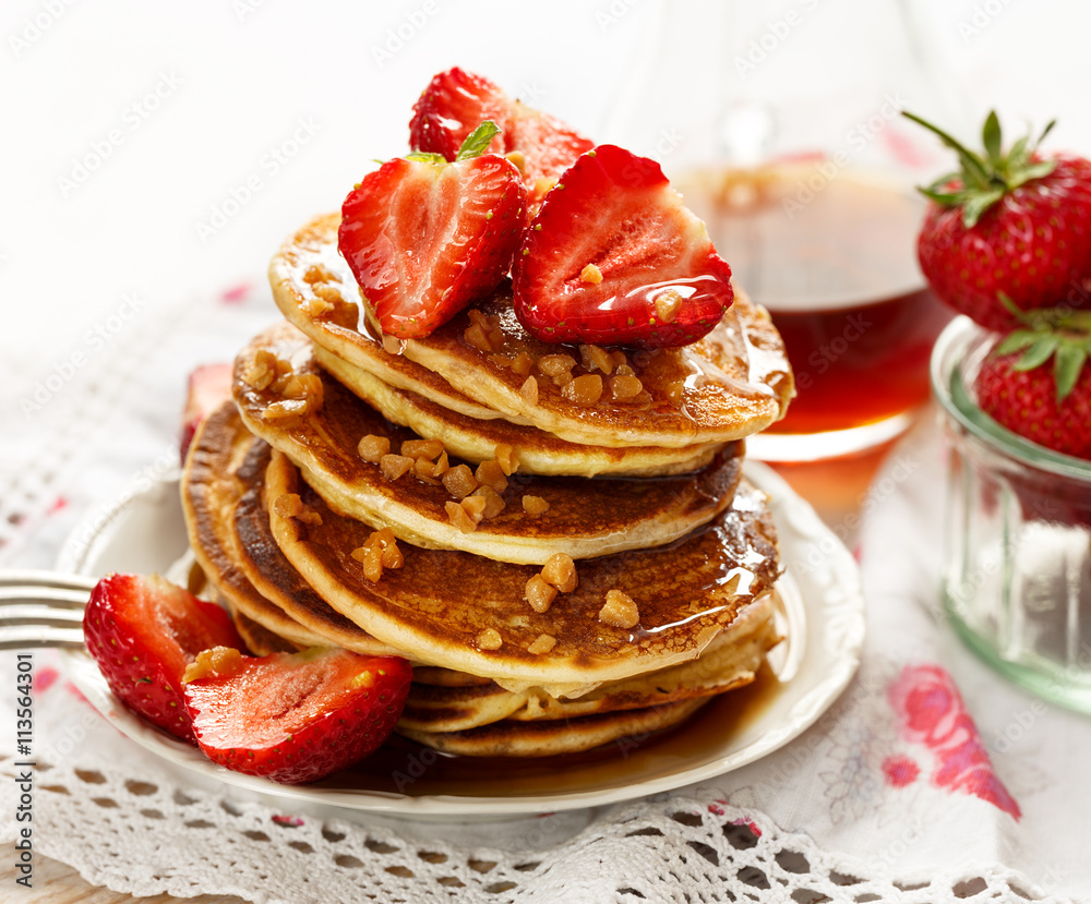 Pancakes with fresh strawberries, maple syrup and caramel topping Pancakes with fresh strawberries, maple syrup and caramel topping