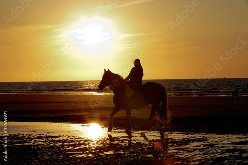 Reiterin in Abendsonne am Meer