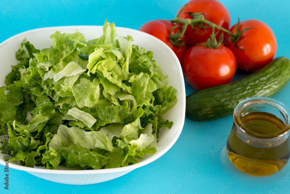 Fresh tomato, lettuce and cucumber for salad with olive oil Fresh tomato, lettuce and cucumber for salad with olive oil