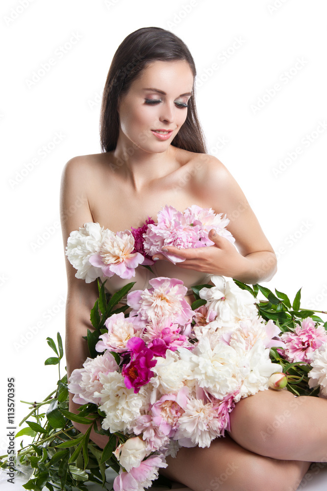 beautiful girl with flowers peonies. Portrait of a young woman with a dress of flowers.
