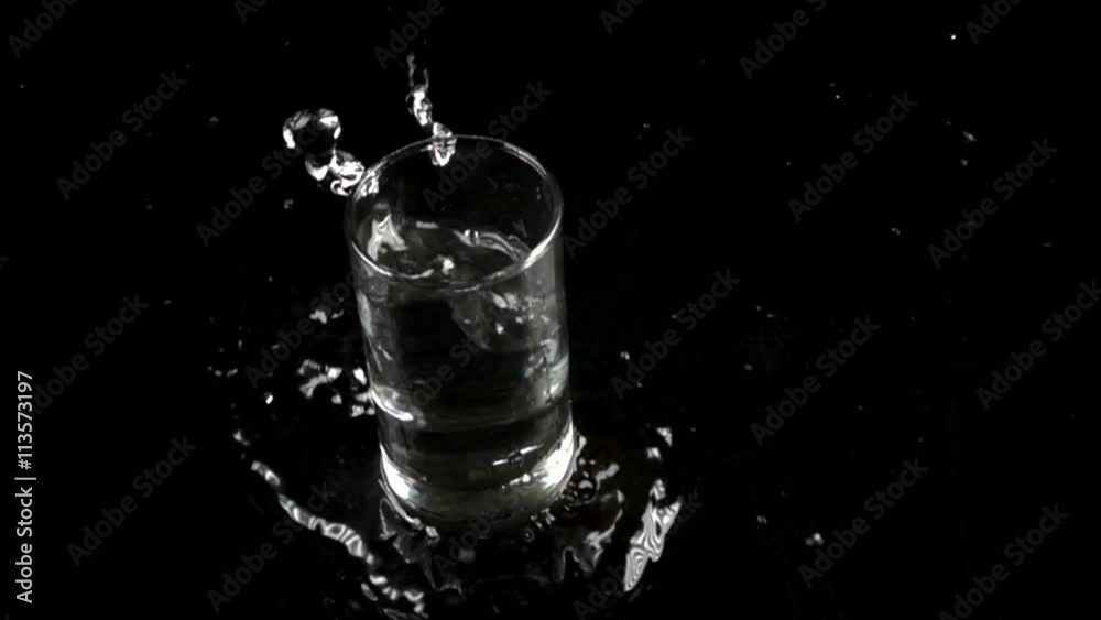 Small glass of water falling down on water surface. 500 fps super slow motion Small glass of water falling down on water surface. 500 fps super slow motion