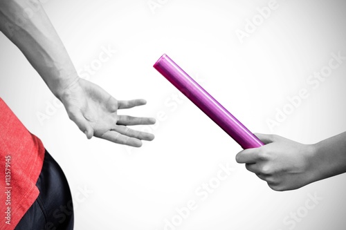 Athlete passing a baton to the partner