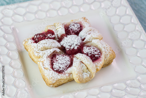 Fresh baked berries cream cheese pastry on a white plate..