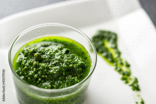 Basil pesto sauce. Fresh homemade basil pesto sauce in a glass jar. Originally from italy, pesto is commonly made with basil and used as a sauce for pasta.
