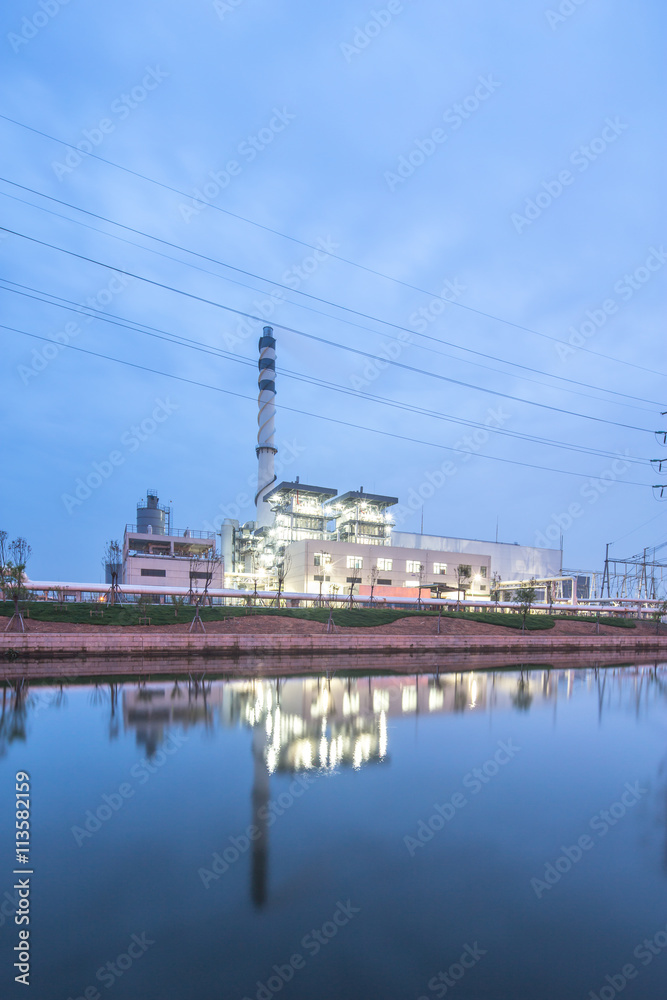 modern power station near river at twilight