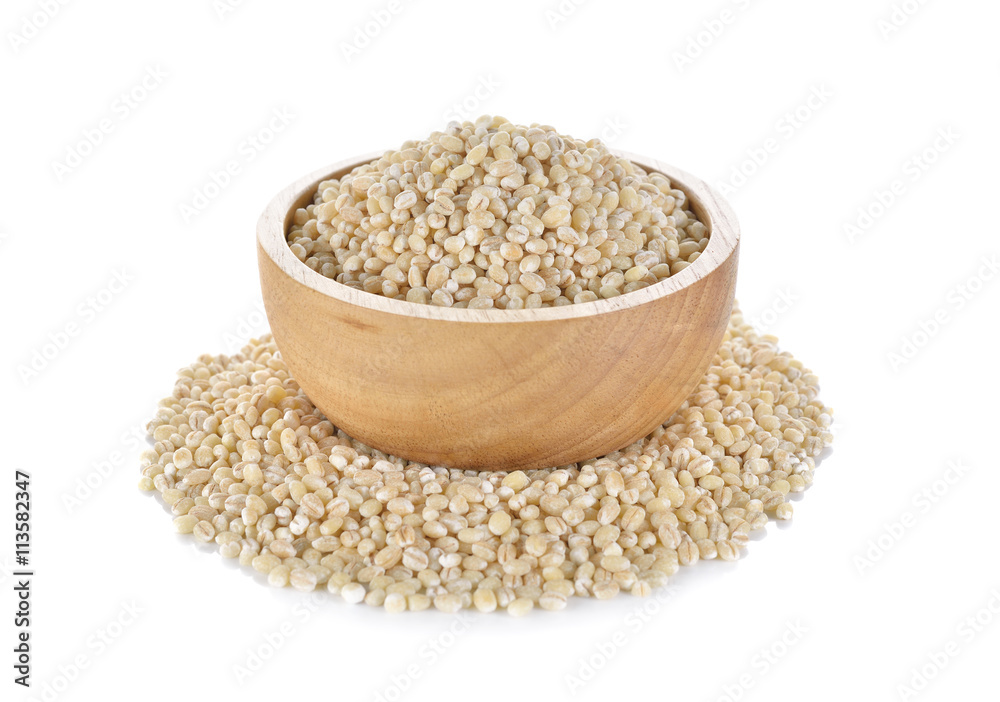 Uncooked barley grain seeds in wooden bowl and on white backgrou Uncooked barley grain seeds in wooden bowl and on white backgrou