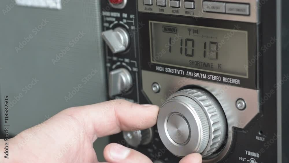 Tuning radio station. Hand of man turning dial of a radio and adjusting volume. Tuning radio station. Hand of man turning dial of a radio and adjusting volume.