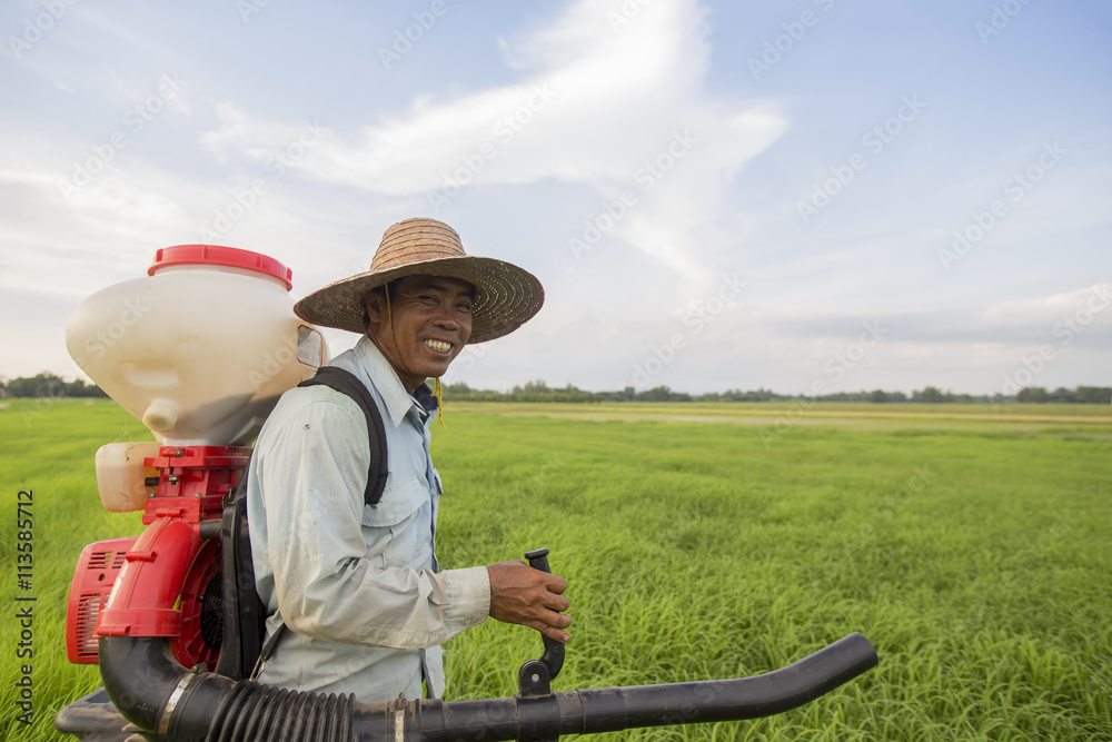 smile farmer spraying pesticide during sunset time