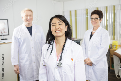 Happy Female Doctor Standing With Colleagues