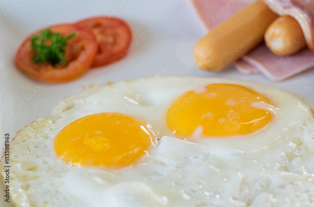 Fried eggs with bacon and hotdog, traditional breakfast Fried eggs with bacon and hotdog, traditional breakfast